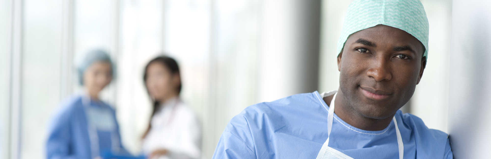 Doctor in Surgical Gown With Doctors Behind Him